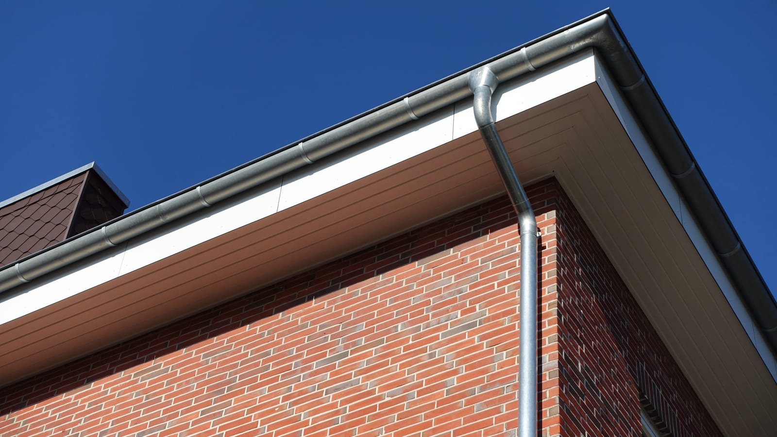 New guttering and fascia on a house against a blue sky